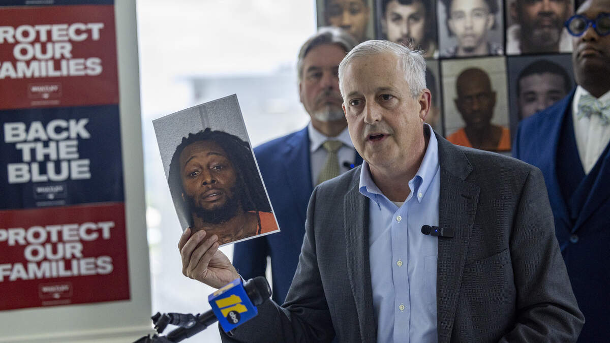 Republican U.S. Senate candidate Michael Whatley holds up a photograph of Decarlos Brown Jr., a Charlotte man accused of killing Ukrainian refugee Iryna Zarutska, during a news conference at his campaign headquarters in Raleigh on July 9, 2026. Whatley was formally announcing the endorsement he received from the North Carolina Police Benevolent Association.