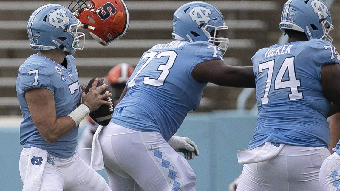 North Carolina quarterback Sam Howell (7) gets protection from Marcus McKethan (73) and Jordan Tucker (74) as an errant Syracuse helmet flies over the offensive line in the first quarter at Kenan Stadium on Saturday, September 12, 2020 in Chapel Hill, N.C.
