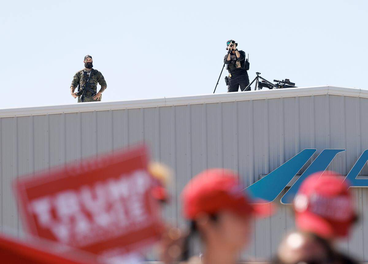 Law enforcement keeps watch from atop a building during the arrival of former President and current Republican candidate for president Donald Trump in Wilmington, N.C. on Saturday, Sept. 21, 2024.