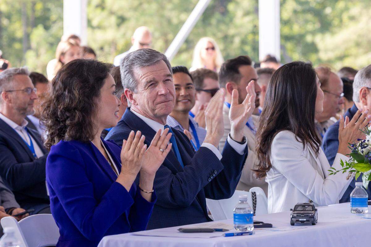 VinFast CEO Le Thi Thu Thuy and Gov. Roy Cooper clap during a groundbreaking ceremony Friday at the future site of a VinFast plant in Moncure.