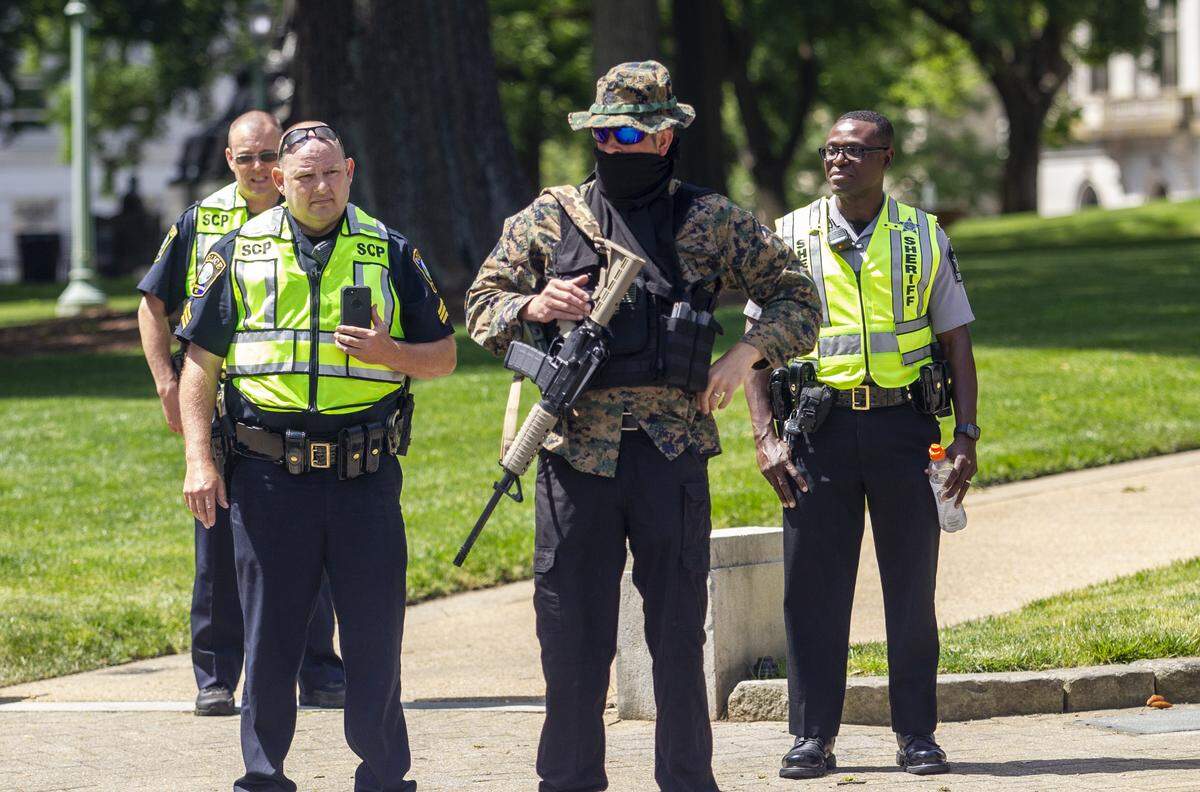 Adam Smith, an organizer with the ReOpen NC group is asked by Capitol Police to leave the State Capitol property while he demonstrated with group of about a half dozen mostly armed demonstrators affiliated with the Facebook group Blue Igloo as they marched in downtown Raleigh Saturday, May, 16, 2020.