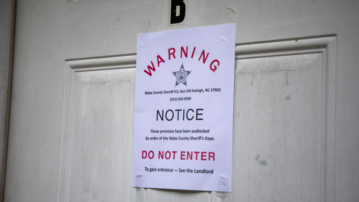 A padlock notice is taped to the door of an apartment, whose tenant was unavailable for comment, on Wednesday, Aug. 19, 2020, in Raleigh, N.C.