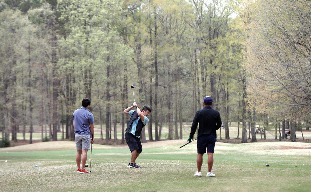 Golfers tee off on the eighth hole at Lochmere Golf Club in Cary, N.C., Monday, March 30, 2020.