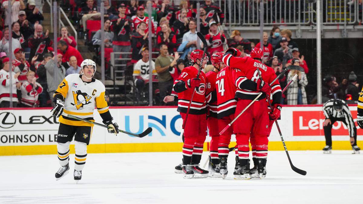 Carolina Hurricanes defenseman Jaccob Slavin (74) is congratulated by defenseman Brent Burns (8) and right wing Andrei Svechnikov (37) after his goal against the Pittsburgh Penguins during the second period at Lenovo Center.