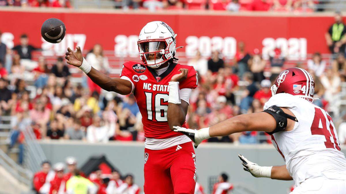 N.C. State quarterback CJ Bailey (16) passes as Stanford defensive lineman Tobin Phillips (40) closes in during the first half of N.C. State’s game against Stanford at Carter-Finley Stadium in Raleigh, N.C., Saturday, Nov. 2, 2024.
