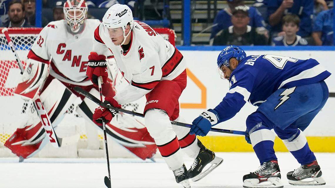 Carolina Hurricanes defenseman Brendan Smith (7) gets hooked by Tampa Bay Lightning left wing Pierre-Edouard Bellemare (41) during the first period of an NHL hockey game Tuesday, March 29, 2022, in Tampa, Fla. (AP Photo/Chris O’Meara)