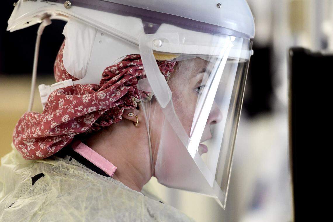 Brianna Hilger, CNA, prepares to enter the room of a coronavirus patient in the the Special Respiratory Isolation intensive care unit at UNC Rex Hospital Wednesday, May 6, 2020. She is wearing a protective MAXAIR which incorporates an air purifying respirator with a sealed face shield.