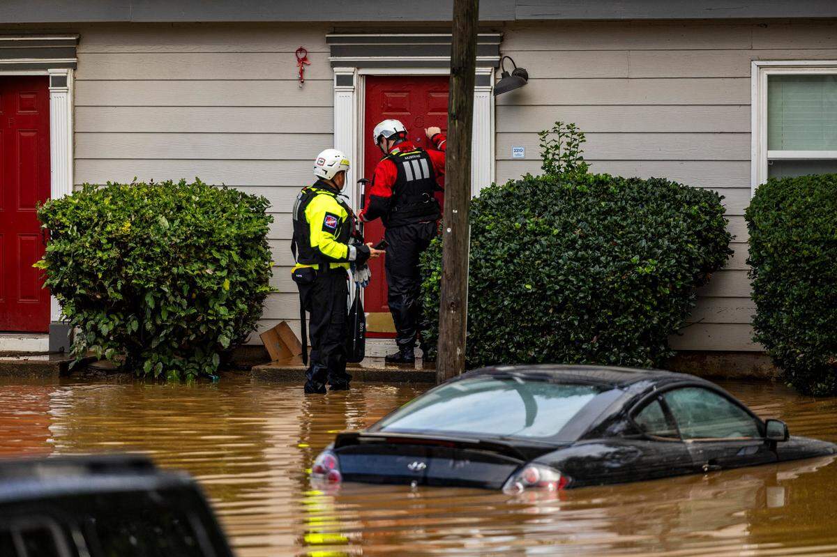 A water rescue unit with the Durham Fire Department knocks on doors at Rippling Streams Townhomes in the Old Farm neighborhood along the Eno River in Durham on Monday morning, July 7, 2025, after flash flooding caused by Tropical Storm Chantal.