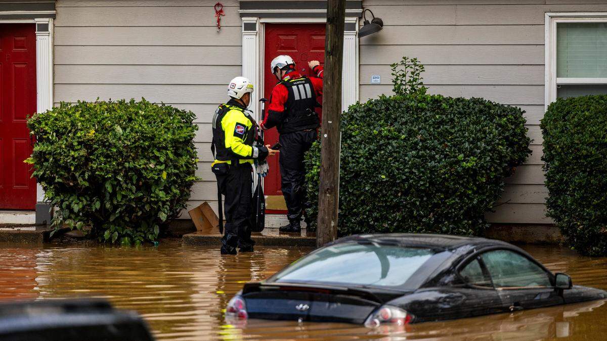 A water rescue unit with the Durham Fire Department knocks on doors at Rippling Streams Townhomes in the Old Farm neighborhood along the Eno River in Durham on Monday morning, July 7, 2025, after flash flooding caused by Tropical Storm Chantal.