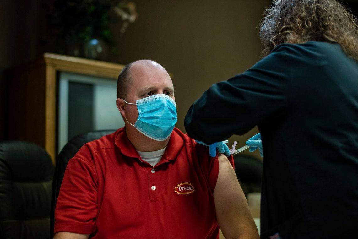 In this Feb. 3, 2021, file photo, a Tyson Foods team member receives a COVID-19 vaccine at meatpacking plant in Wilkesboro, N.C. Meatpacking workers have started receiving coronavirus vaccines and thousands more will have a chance to get their first shots, offering some peace of mind in an industry that was ravaged by COVID-19 a year ago.