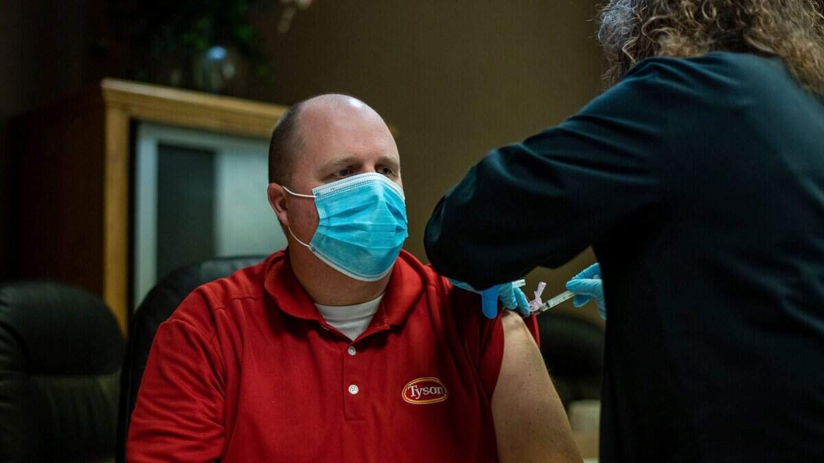 In this Feb. 3, 2021, file photo, a Tyson Foods team member receives a COVID-19 vaccine at meatpacking plant in Wilkesboro, N.C. Meatpacking workers have started receiving coronavirus vaccines and thousands more will have a chance to get their first shots, offering some peace of mind in an industry that was ravaged by COVID-19 a year ago.