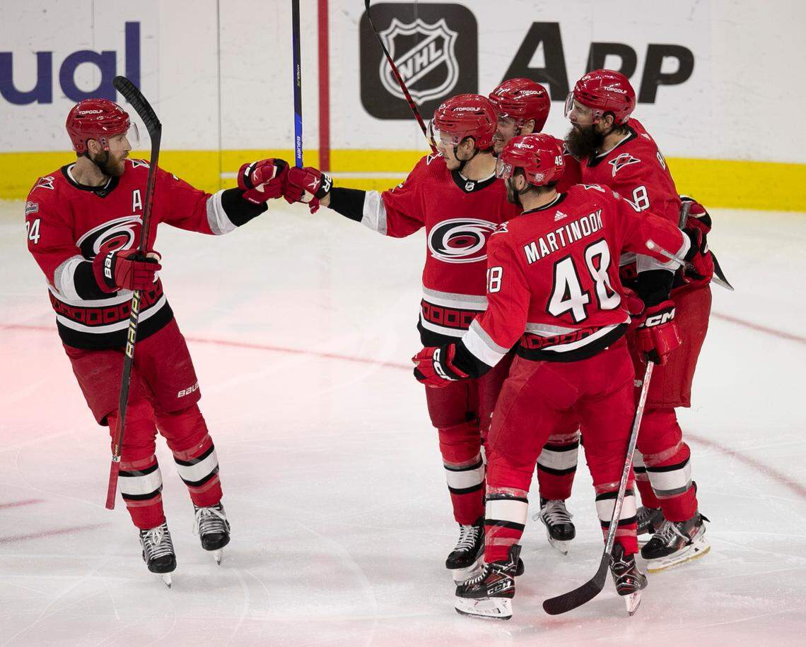 The Carolina Hurricanes Jaccob Slavin (74) congratulates Jesperi Kotkaniemi (82) after Kotkaniemi scored in the second period to take 3-0 lead over the New Jersey Devils during Game 1 of their second round Stanley Cup playoff series on Wednesday, May 3, 2023 at PNC Arena in Raleigh, N.C.
