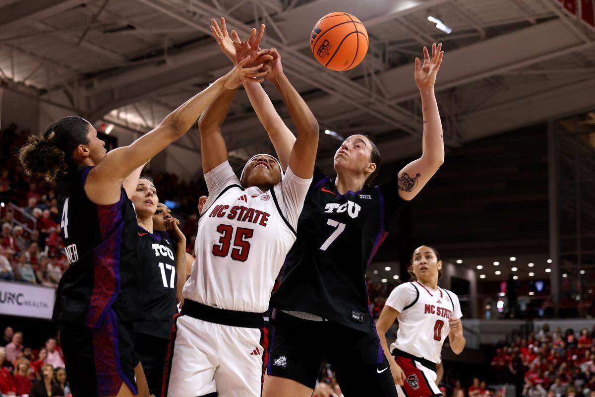 Zoe Brooks (35) of N.C. State battles for a rebound against Donovyn Hunter (4) and Marta Suarez (7) of TCU in the first half at Reynolds Coliseum on Nov. 16, 2025 in Raleigh, North Carolina.