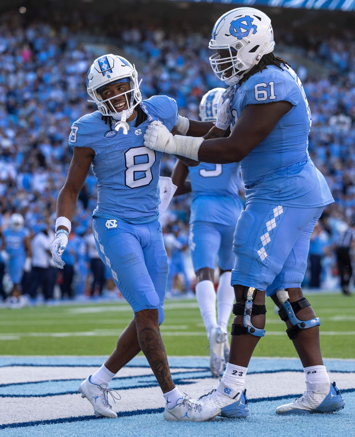 North Carolina’s Diego Pounds (61) congratulates teammate Kobe Paysour (8) after he scored on a 76-yard pass from quarterback Drake Maye to give the Tar Heels’ a 37-7 lead in the third quarter on Saturday, October 7, 2023 at Kenan Stadium in Chapel Hill, N.C