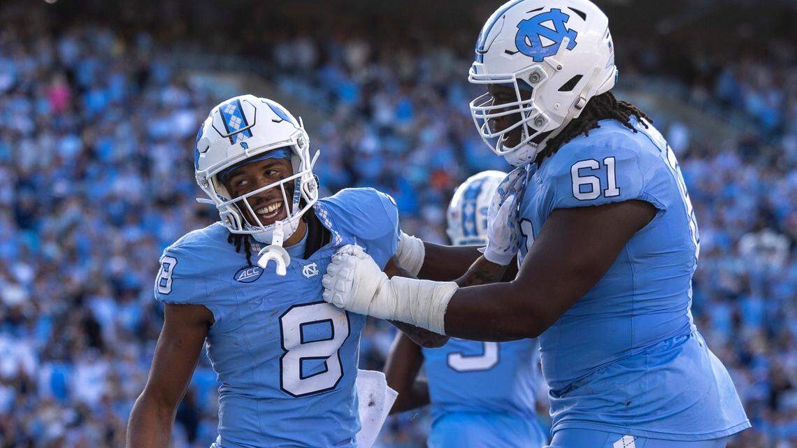 North Carolina’s Diego Pounds (61) congratulates teammate Kobe Paysour (8) after he scored on a 76-yard pass from quarterback Drake Maye to give the Tar Heels’ a 37-7 lead in the third quarter on Saturday, October 7, 2023 at Kenan Stadium in Chapel Hill, N.C