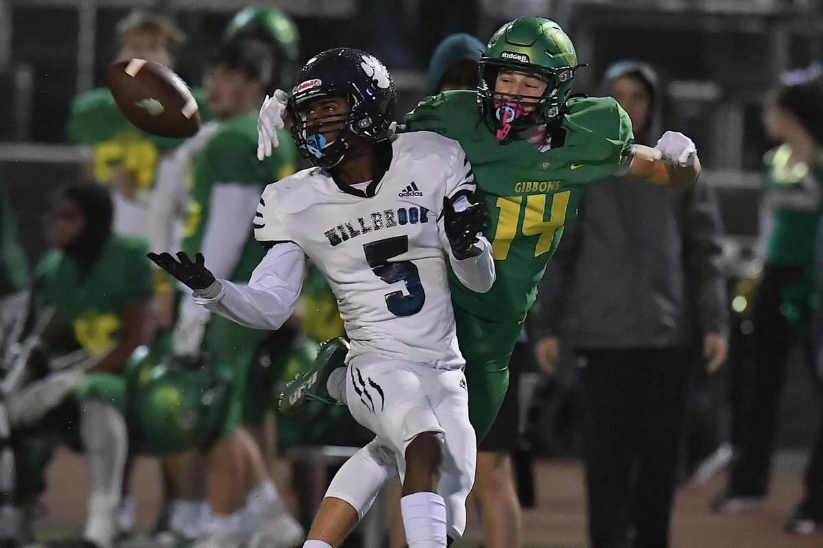 Millbrook’s Session McArthur (5) attempts the interception against Cardinal Gibbons’ Chey Yardley (14) during the first half. The Cardinal Gibbons Crusaders and the Millbrook Wildcats met in a NCHSAA 4A playoff game in Raleigh, NC on November 10, 2022