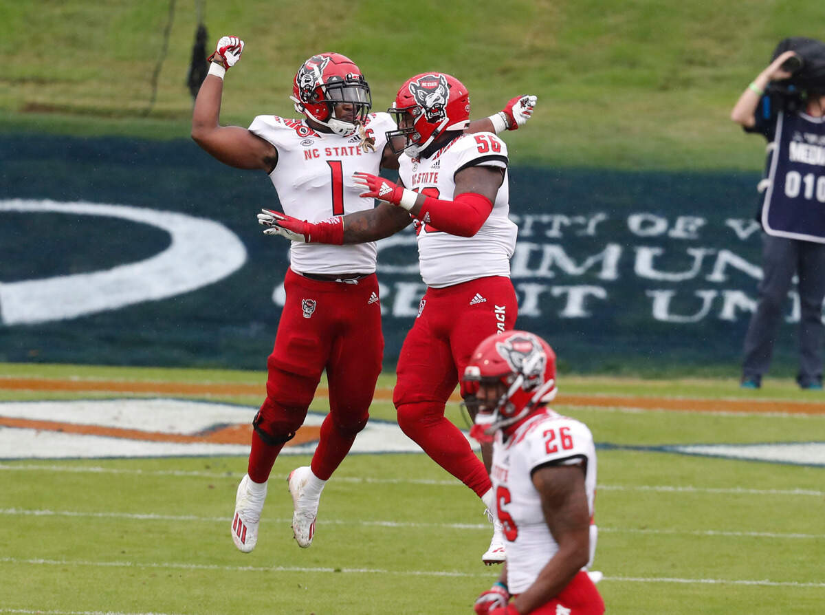 N.C. State linebacker Isaiah Moore (1) celebrates with Val Martin (56) after the Wolfpack stopped Virginia on fourth and one at the goal line during the first half of N.C. State’s game against Virginia at Scott Stadium in Charlottesville, Va., Saturday, Oct. 10, 2020.
