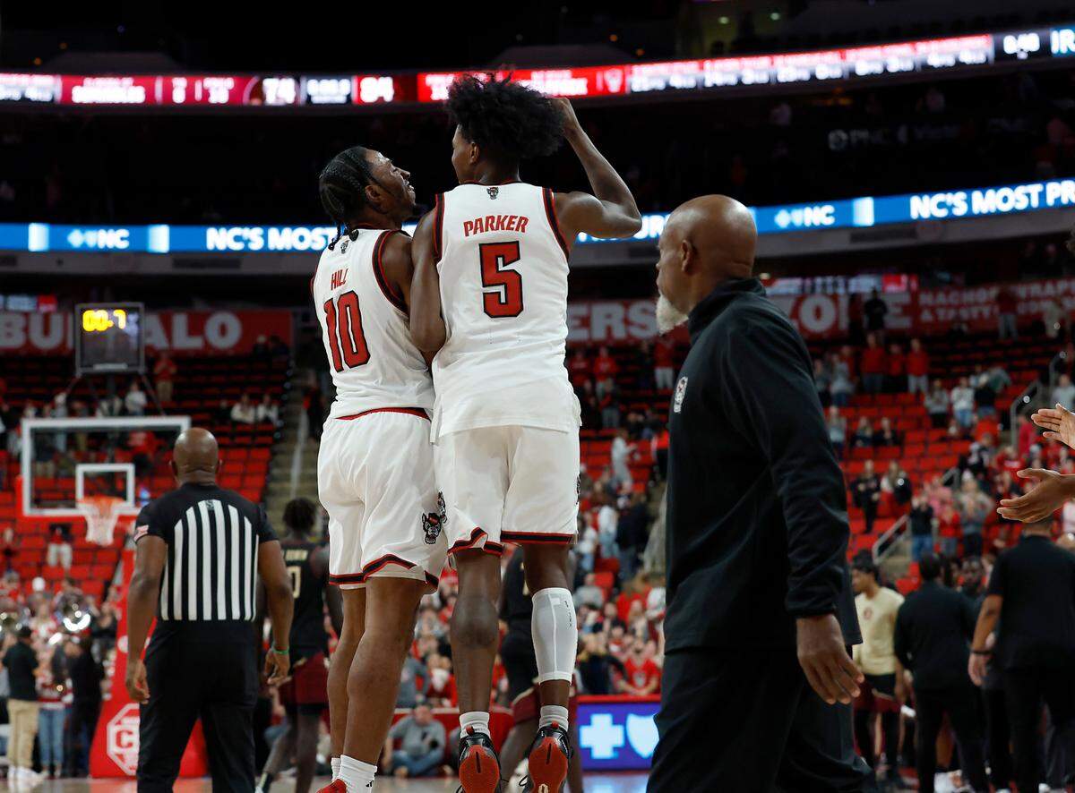 N.C. State’s Marcus Hill and Trey Parker celebrate in the closing seconds of the Wolfpack’s 84-74 overtime win over Florida State on Saturday, Dec. 7, 2024, at Lenovo Center in Raleigh, N.C.