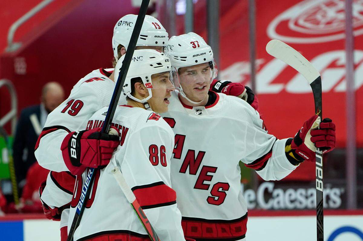 Carolina Hurricanes right wing Andrei Svechnikov (37) celebrates his goal with Dougie Hamilton (19) and Teuvo Teravainen (86) against the Detroit Red Wings in the second period of an NHL hockey game Saturday, Jan. 16, 2021, in Detroit. (AP Photo/Paul Sancya)