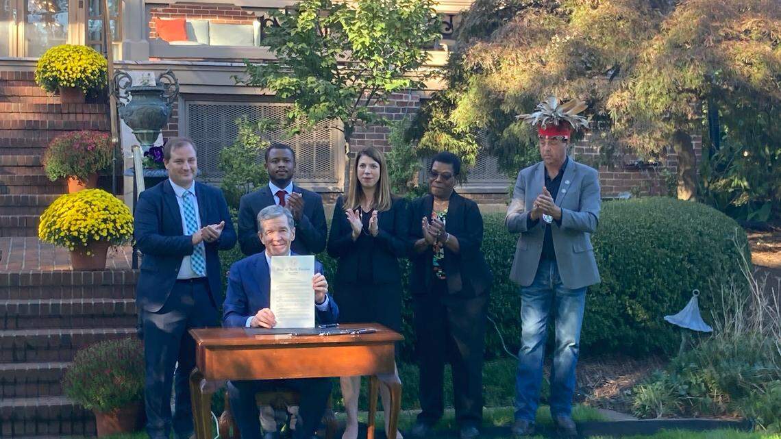 Gov. Roy Cooper holds up a signed copy of Executive Order 292 during an Oct. 24, 2023, ceremony at the N.C. Executive Mansion that also featured N..C. Department of Environmental Quality Secretary Elizabeth Biser and environmental advocates. The order shifted the state’s environmental justice advisory board from DEQ to a Governor’s Council and tasked the state’s Department of Information Technology with creating a mapping tool that gathers resource from across state government, among other steps.