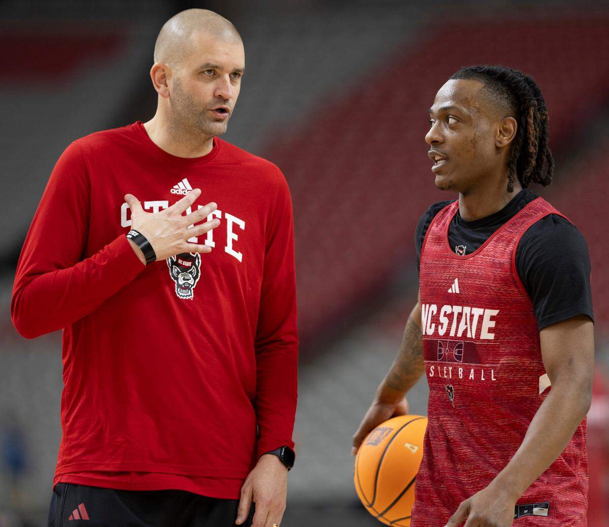 N.C. State assistant coach Joel Justus talks with D.J. Horne (0) during their practice on Friday, April 5, 2024, as they prepare for their NCAA National Semi-Final game against Purdue at State Farm Stadium in Glendale, AZ.