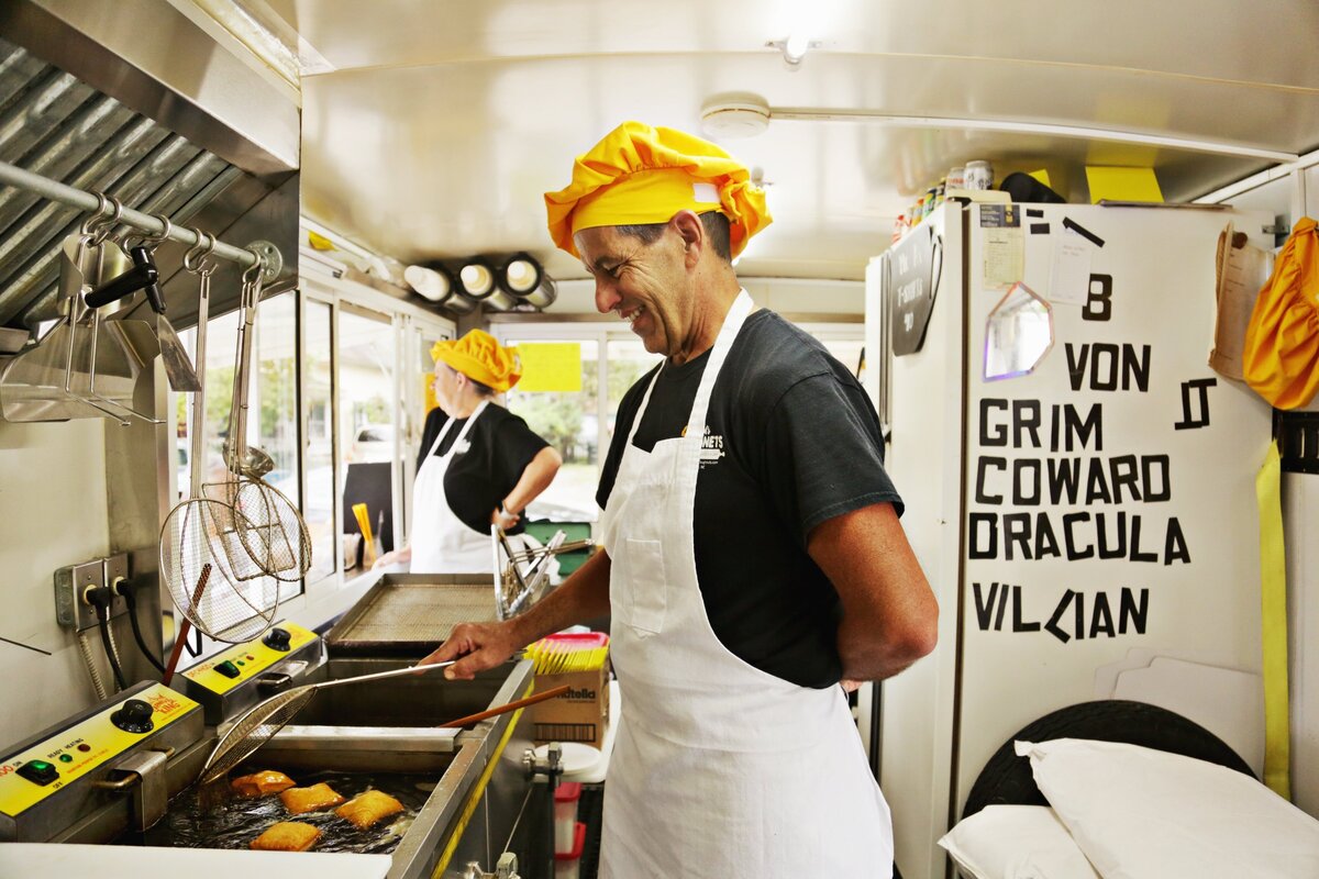 Arlton Cangelosip, right, makes fresh beignets as Joelle Lynde, left, takes orders from the window of Mr. A’s Beignet’s food truck on Thursday morning, Nov. 1, 2018, in Apex.