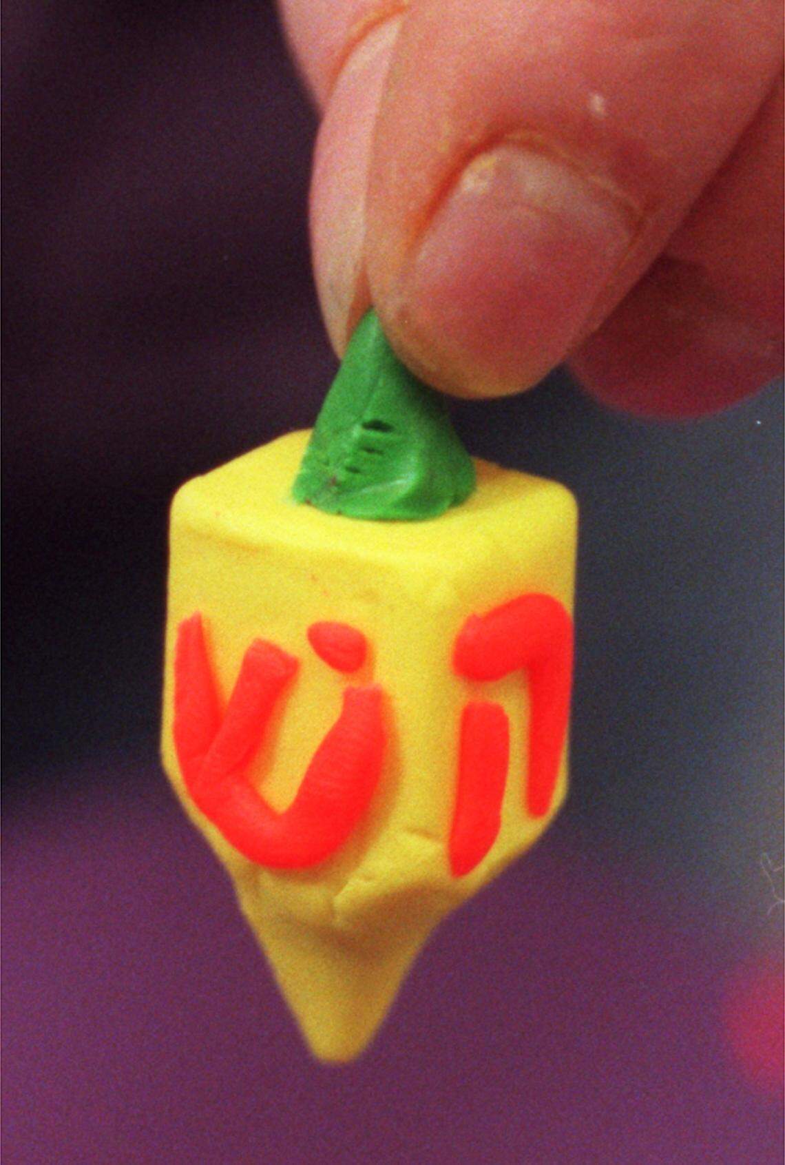 At a Hanukkah celebration at the Jewish Community Center on Norwood Road in North Raleigh in 2009, parents and kids participated in the traditional activities of the holiday, including cooking potato latkes, making dreidels (pictured here) and playing games with them, pressing olives for oil and lighting the Menorah.