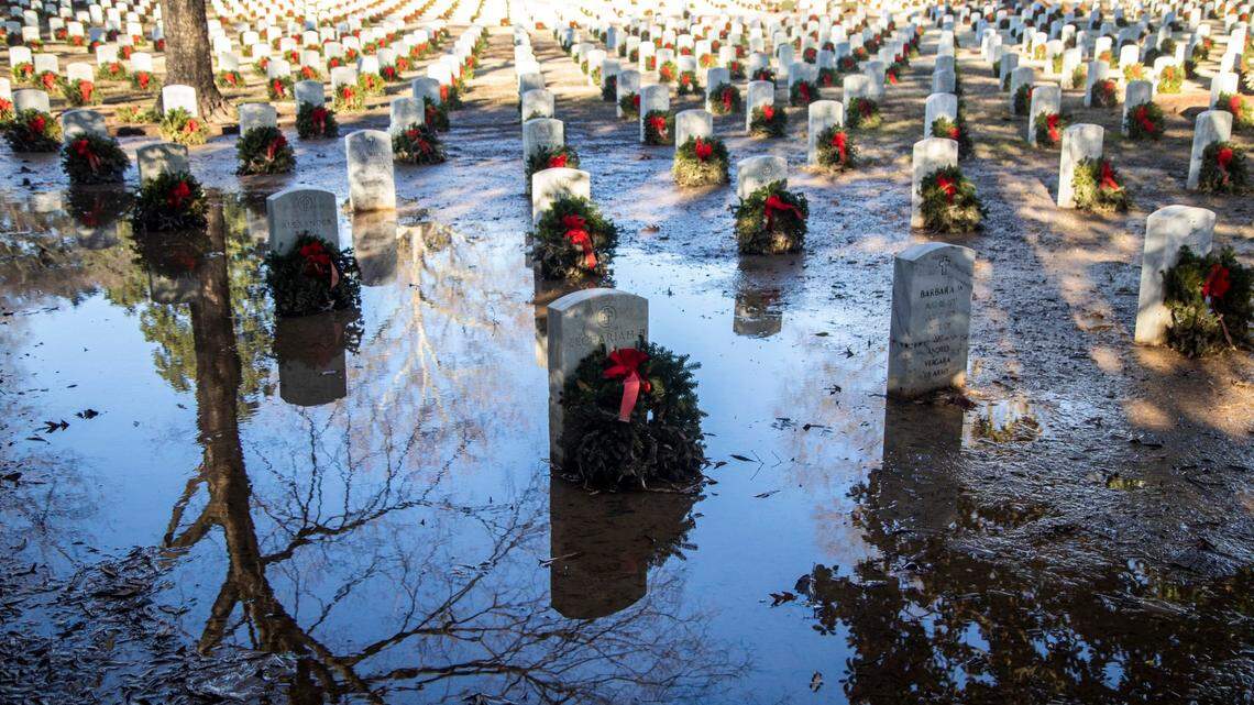 Graves sit in mud and standing water in the southeast corner of the Raleigh National Cemetery days after heavy rains Tuesday, Dec. 29, 2020.
