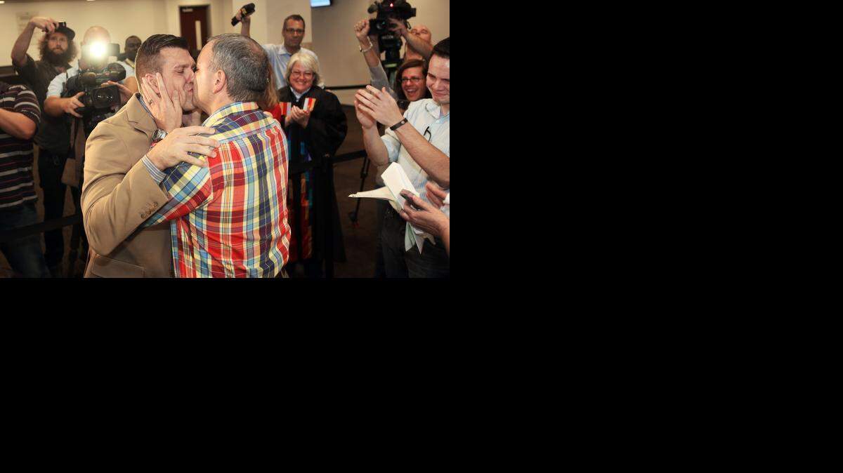 Chad Biggs, left, and his partner, Chris Creech, kiss after exchanging wedding vows Friday at the Wake County Courthouse in Raleigh.  They were the first gay couple to be married in Wake County.
