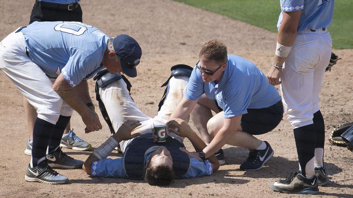 North Carolina coach Mike Fox and trainer Terri Jo Rucinski attend to catcher Cody Roberts after he was hit by a foul ball in the seventh inning against Duke on Sunday, May 13, 2018, at Durham Bulls Athletic Park in Durham, N.C.