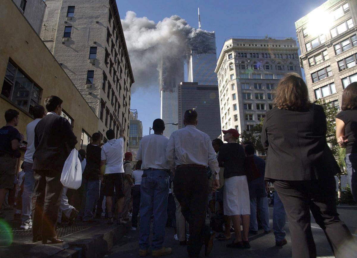 Pedestrians in lower Manhattan watch smoke billow from New York’s World Trade Center on Tuesday, Sept. 11, 2001.
