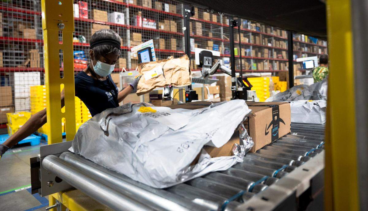 An Amazon worker scans and moves packages in the Same-Day Delivery Fulfillment Center in Durham on Wednesday, July 10, 2024.