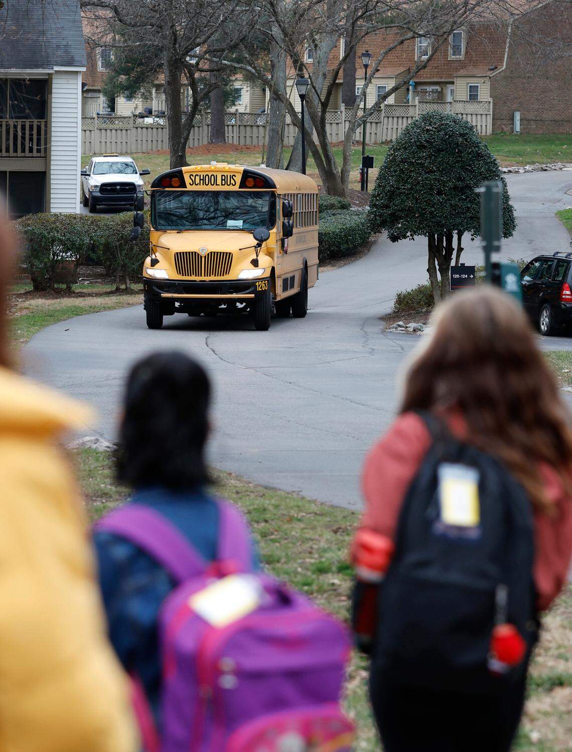 Heather Wilson, her daughter, Ady, and others wait for the school bus to take them to Farmington Woods Elementary School Thursday morning, Jan. 12, 2023.