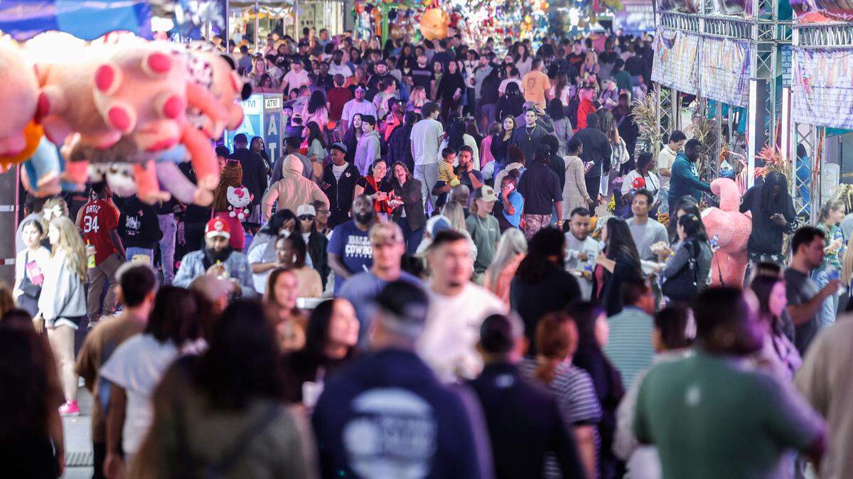 Fairgoers walk the midway at the N.C. State Fair in Raleigh on the evening of Oct. 24, 2024.