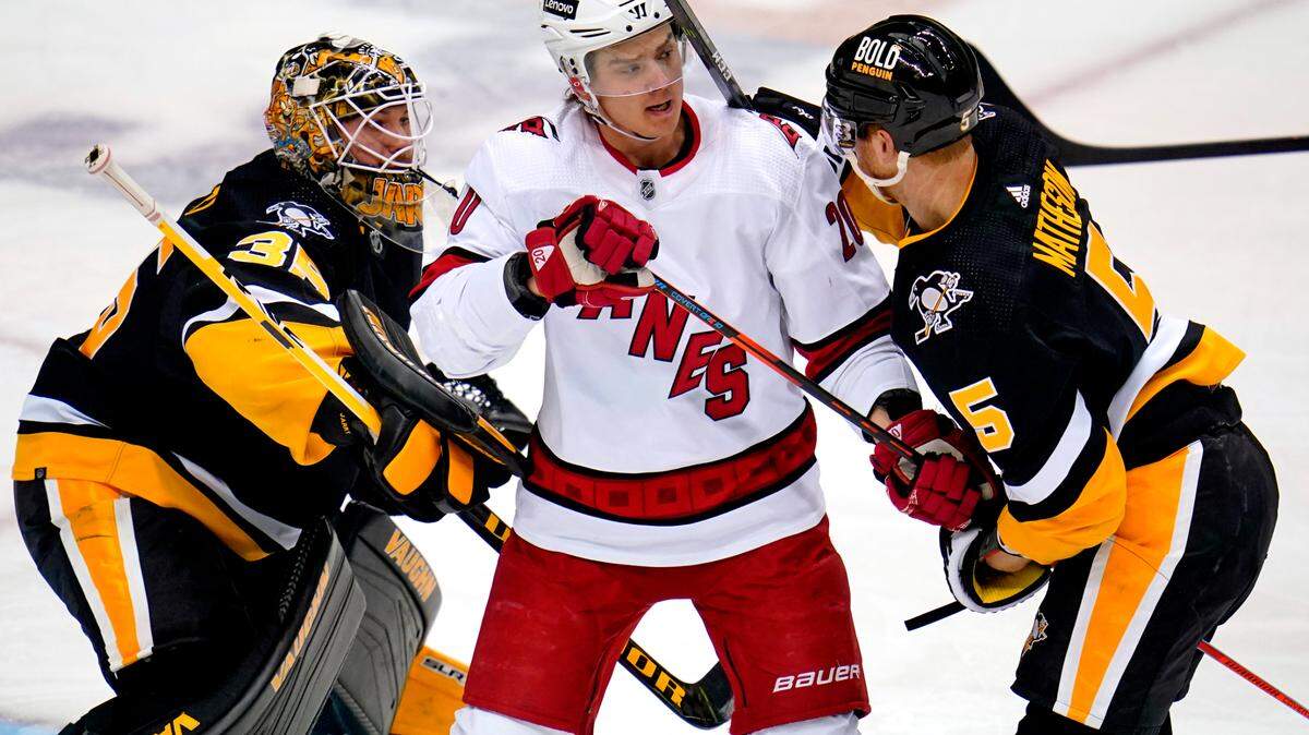 Carolina Hurricanes’ Sebastian Aho (20) screens Pittsburgh Penguins goaltender Tristan Jarry (35) with Mike Matheson (5) defending during the first period of an NHL hockey game in Pittsburgh, Sunday, March 13, 2022. The Penguins won 4-2. (AP Photo/Gene J. Puskar)