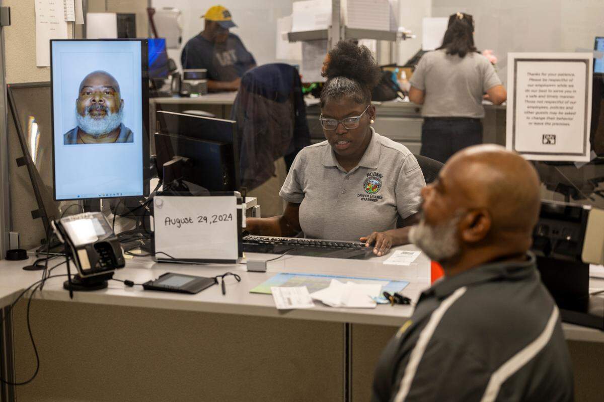 Examiner Tya Barnes makes Sidney Tindall Jr.’s photo for a new driver’s license at the NCDMV office on New Bern Avenue in Raleigh on Thursday, Aug. 29, 2024.