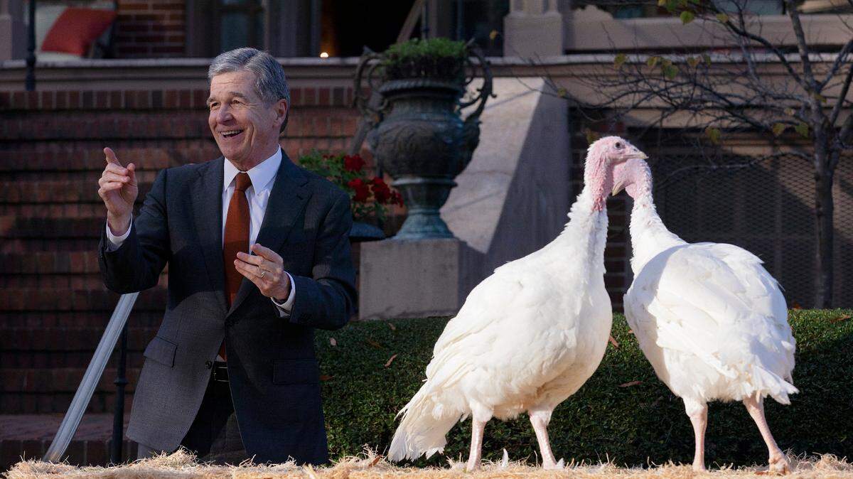 Gov. Roy Cooper smiles as he pardons two turkeys, Ethel and Bertha, in a ceremony at the North Carolina Executive Mansion on Monday, Nov. 25, 2024, in Raleigh, N.C.