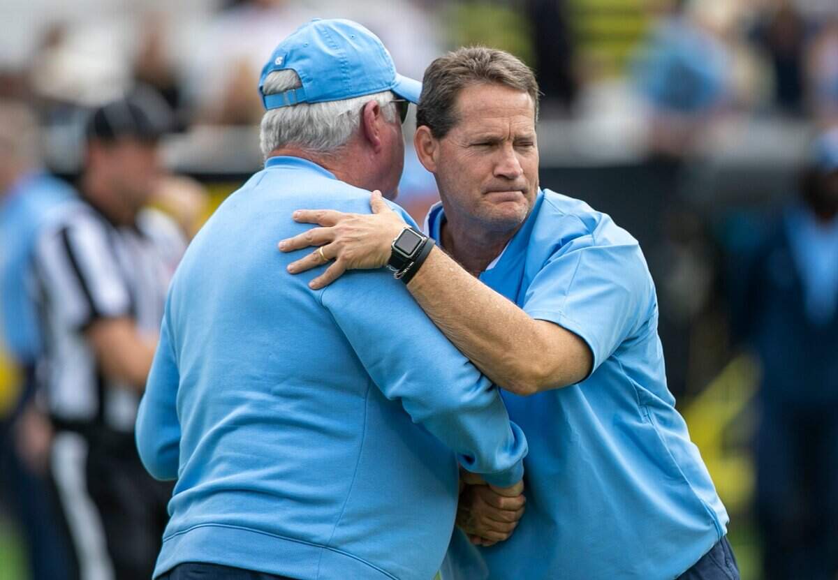 North Carolina defensive coach Gene Chizik embraces head coach Mack Brown prior to the Tar Heels game against Appalachian State on Saturday, September 3, 2022 at Kidd Brewer Stadium in Boone, N.C.