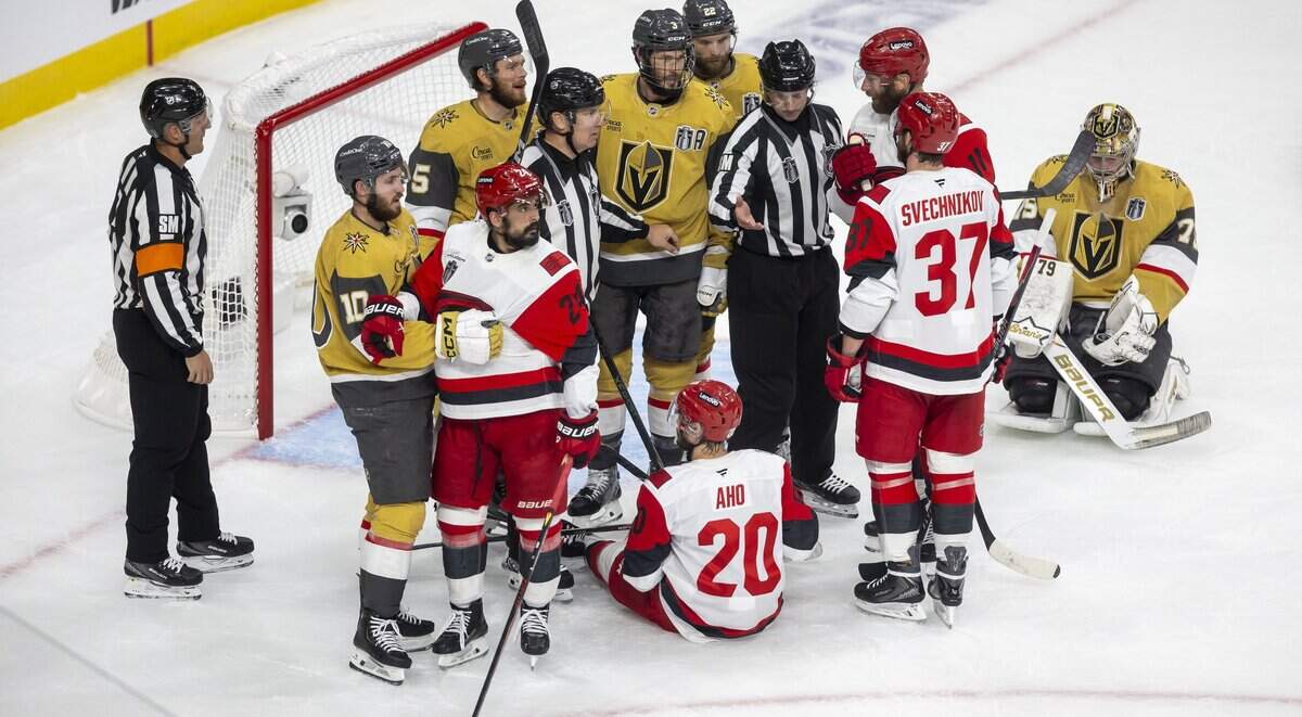 Officials work to keep the peace as Carolina Hurricanes center Sebastian Aho (20) is knocked to the ice in the first period of Game 6 of the Stanley Cup Final, on Sunday, June 14, 2026 at T-Mobile Arena in Las Vegas, NV.