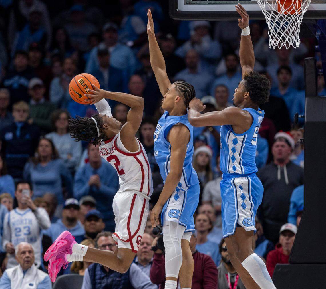 North Carolina’s Harrison Ingram (55) and Seth Trimble (7) defend. Oklahoma’s Javian McCollum (2) in the first half on Wednesday, December 20, 2023 at the Spectrum Center in Charlotte, N.C.