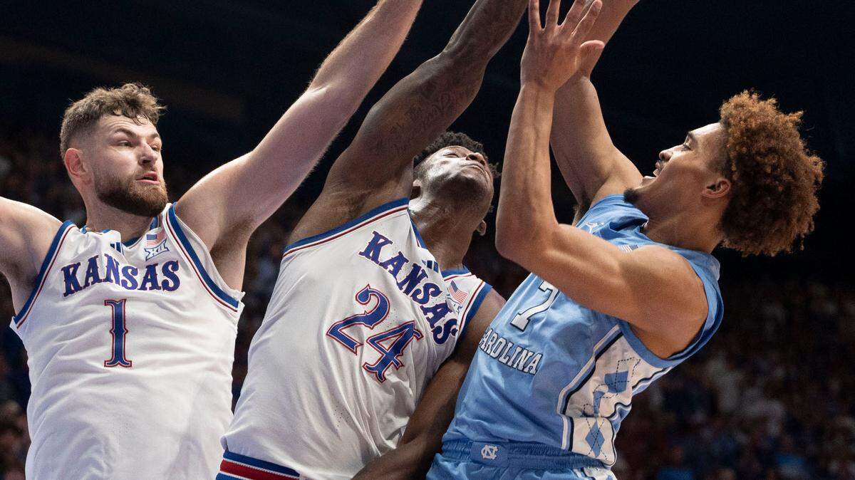 North Carolina guard Seth Trimble (7) puts up a shot against Kansas center Hunter Dickinson (1) and forward K.J. Adams Jr. (24) in the second half on Friday, November 8, 2024 at Allen Fieldhouse in Lawrence, Kansas. Trimble lead North Carolina with 19 points.