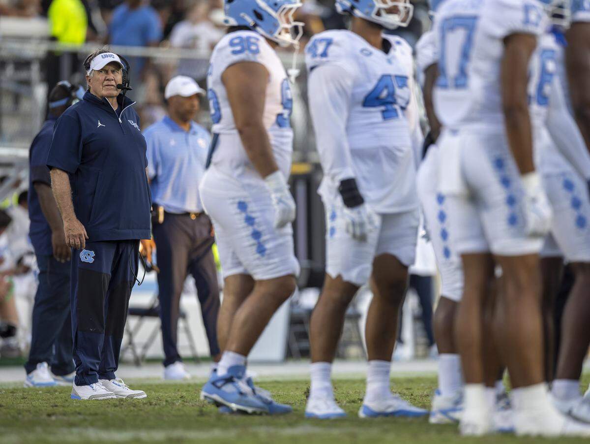 Down 27-9, North Carolina coach Bill Belichick studies the scoreboard during a time-out in the fourth quarter against UCF on Saturday, September 20, 2025 at Acrisure Bounce House Stadium in Orlando, Fla.