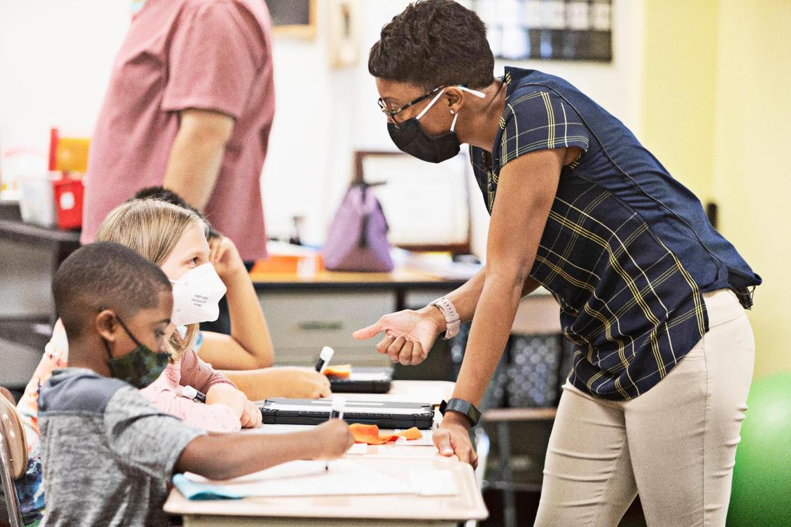 Diann Tucker, a third-grade teacher, helps a student with a math problem during class at Carpenter Elementary School in Cary on Thursday morning, Aug. 19, 2021. North Carolina students will start their third school year dealing with the coronavirus pandemic just as the highly contagious delta variant is rapidly spreading across the state.
