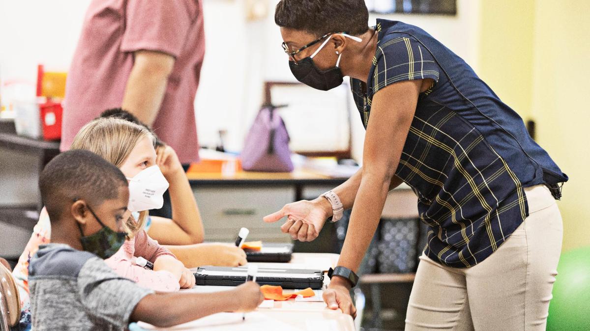 Third-grade teacher Diann Tucker helps a student with a math problem during class at Carpenter Elementary School in Cary on Aug. 19, 2021. Widespread school staffing shortages in North Carolina are affecting everything from the bus routes to how meals are served to who is teaching class.