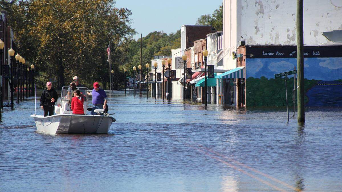 Allen Thompson navigates a boat down Main Street in Fair Bluff, NC, after Hurricane Matthew dumped heavy rains on North Carolina.