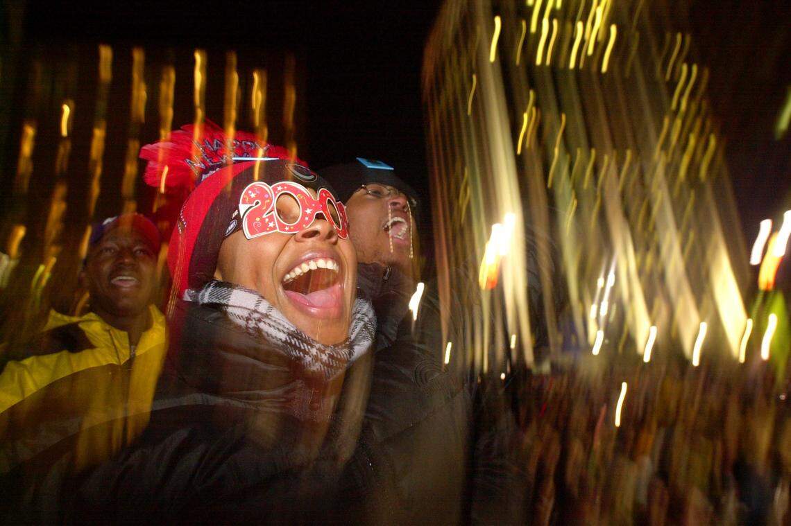 Latrek Morse with the stylish glasses and Anthony Rowes, right, both from Goldsboro, cheer as the big acorn is dropped at the Civic Center Plaza to ring in the new year, January 1, 2000.