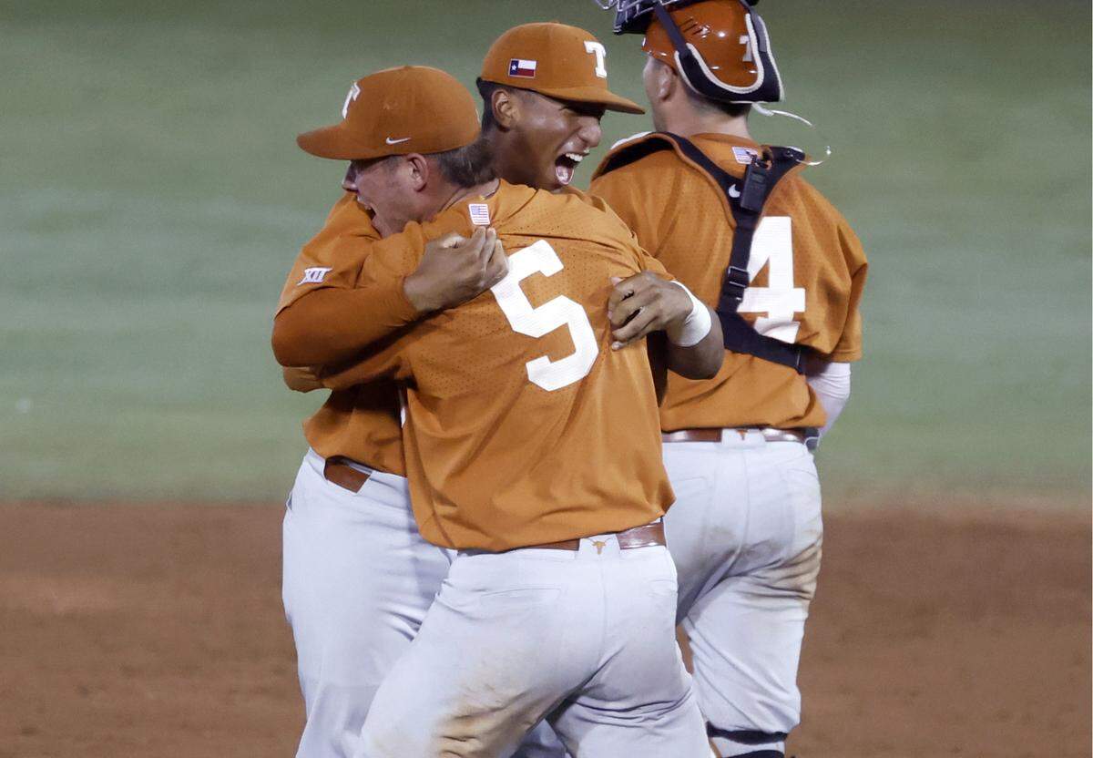 Texas’ Cam Constantine (29), left, celebrates with Skyler Messinger (5) after Texas’ 11-1 victory over ECU to win the Greenville Super Regional at Clark-LeClair Stadium early Monday morning, June 13, 2022.