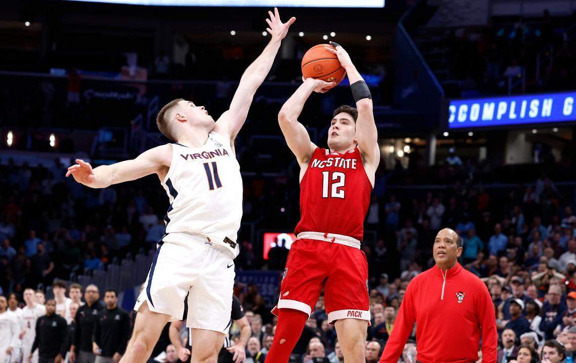 N.C. State’s Michael O’Connell (12) makes a three-pointer as time expires to tie the game in regulation during the Wolfpack’s 73-65 overtime victory over Virginia in the semifinals of the 2024 ACC Men’s Basketball Tournament at Capital One Arena in Washington, D.C., Friday, March 15, 2024. Virginia’s Isaac McKneely (11) defends.