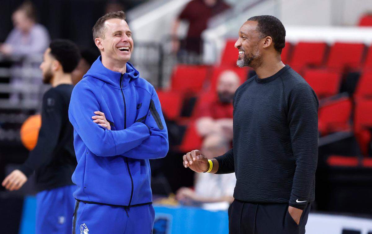 Duke head coach Jon Scheyer laughs with associate head coach Chris Carrawell during Duke’s open practice at the Lenovo Center in Raleigh, N.C., Thursday, March 20, 2025. The Blue Devils will face Mount St. Mary’s in the first round of the NCAA Tournament Friday.