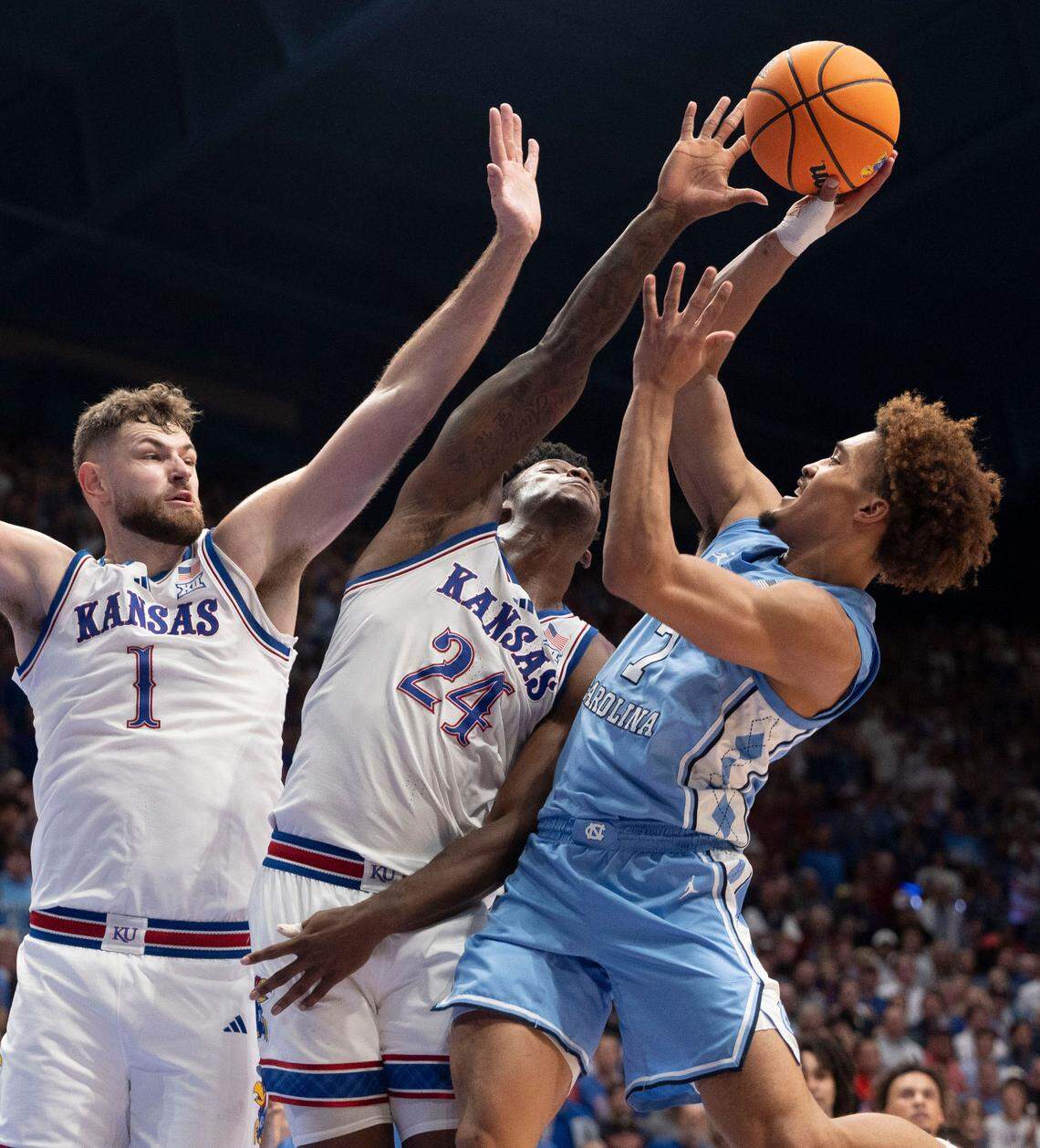 North Carolina guard Seth Trimble (7) puts up a shot against Kansas center Hunter Dickinson (1) and forward K.J. Adams Jr. (24) in the second half on Friday, November 8, 2024 at Allen Fieldhouse in Lawrence, Kansas. Trimble lead North Carolina with 19 points.